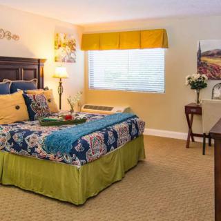 A cozy bedroom with colorful bedding and warm lighting.
