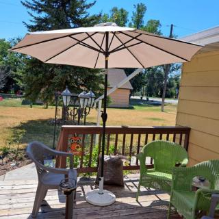 A peaceful backyard patio with a large umbrella and seating area.
