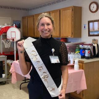 A cheerful celebration with someone wearing a sash, marking a special occasion.