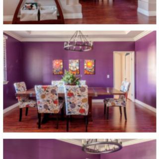 A stylish dining room featuring vibrant purple walls, a chandelier, and floral-patterned chairs around a wooden dining table.
