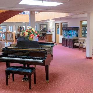 A spacious lobby area featuring a grand piano and various decorative elements.
