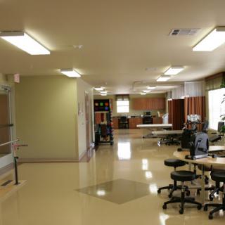 A spacious and well-lit office or workspace featuring desks and ergonomic chairs.
