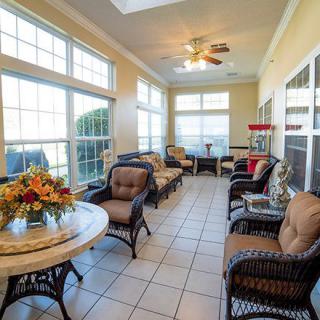 A cozy sunroom with ample natural light, featuring comfortable seating and elegant decor.