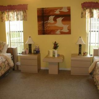 A cozy bedroom with twin beds, nightstands, and decorative lamps.
