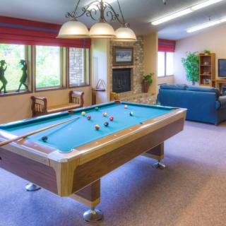 A recreational room featuring a pool table and cozy seating area.