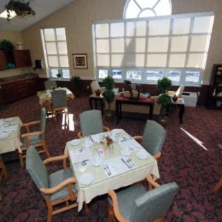 A spacious dining area with neatly arranged tables and chairs, large windows, and tasteful decor.