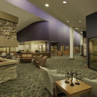 Spacious hotel lobby with modern furniture and a cozy fireplace.