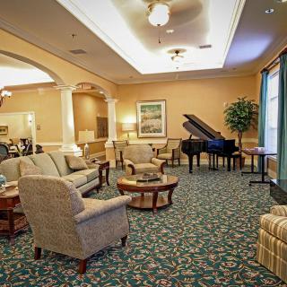 A cozy lounge with comfortable seating and a grand piano.
