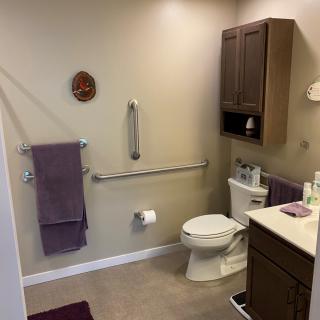 Accessible bathroom with grab bars and towels.