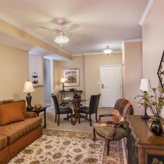 A cozy living room with a sofa, dining area, and elegant decor.