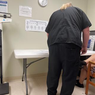 A healthcare worker assists a patient in a medical clinic.