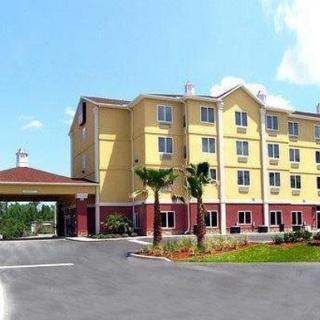 A large hotel building with a driveway and landscaped surroundings under a clear sky.