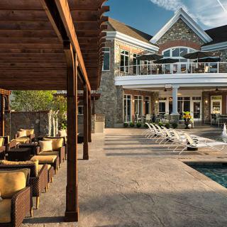 A luxurious home featuring a modern outdoor seating area, swimming pool, and spacious patio.