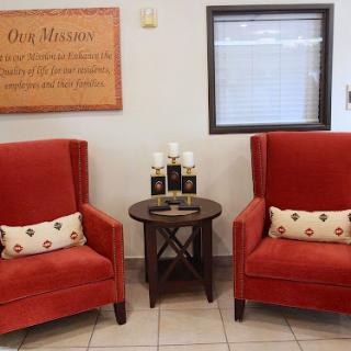 A cozy seating area featuring two elegant red chairs and a small side table, perfect for relaxation.