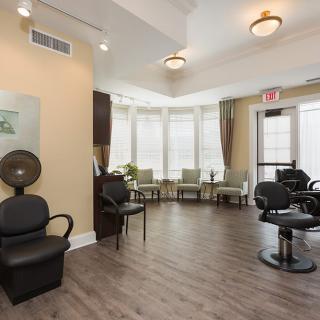 A modern salon interior with a waiting area and hair styling stations.
