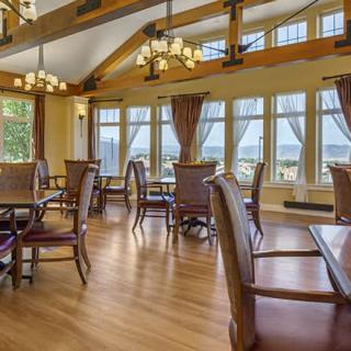 A spacious dining room with large windows and elegant chandeliers.