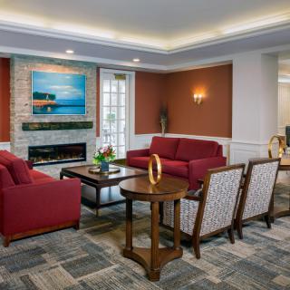 A cozy and stylish living room with red sofas, a fireplace, and modern artwork.