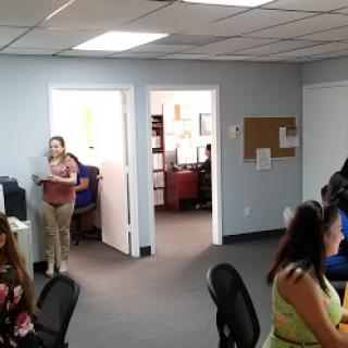 An office environment with employees engaged in work and interactions.