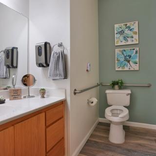 A well-designed bathroom with a toilet, sink, and decorative wall art.