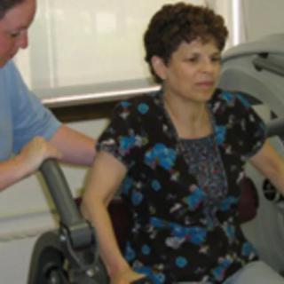 A woman receives assistance during a physical therapy session.