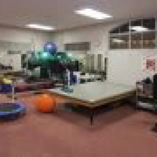 A rehabilitation room equipped with various exercise tools and therapy equipment.