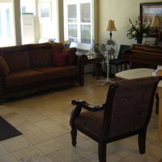 A cozy living room with a sofa, chair, and table near large windows.