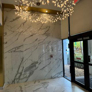 A stylish lobby featuring elegant marble walls and decorative lighting.