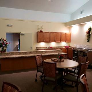 A cozy kitchen and dining area with wooden cabinets and a round table surrounded by chairs.