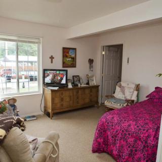 A cozy living space featuring a bed, television, and various decor items.