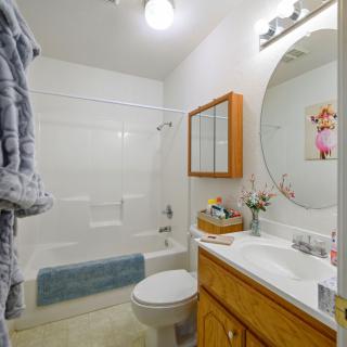 A clean and organized bathroom with a wooden cabinet, shower, and neatly arranged towels.