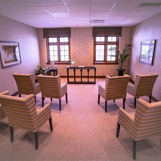 A therapy room with a circular seating arrangement of chairs, designed for group meetings.