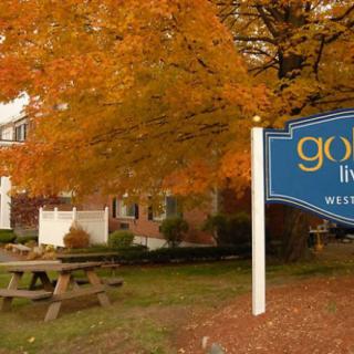 A sign for Gold Leaf Westgate with autumn foliage in the background.