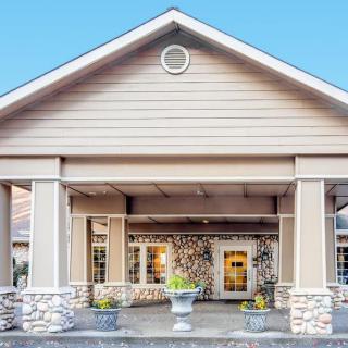 A building entrance with a covered porch featuring stone columns and a welcoming appearance.