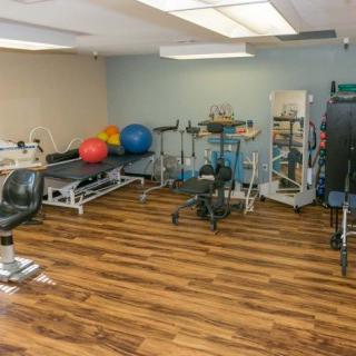 A fitness room equipped with various exercise machines and therapy equipment.