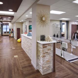 A modern rehabilitation center with an open and welcoming interior design, featuring exercise equipment for physical therapy.