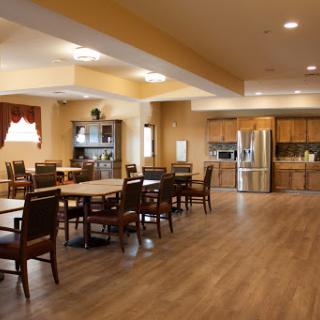 A spacious and inviting dining area featuring wooden furniture and a modern kitchen.