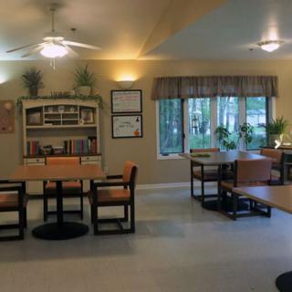 A cozy dining area with tables, chairs, and natural light.
