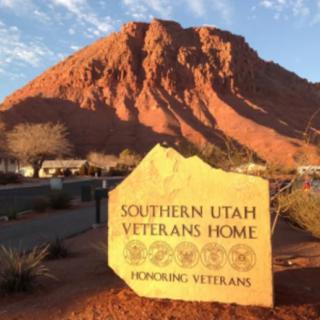Entrance sign for the Southern Utah Veterans Home with a red rock mountain in the background.