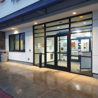 The entrance of a modern commercial building featuring large glass doors.