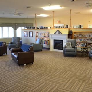 A cozy reading area in a library featuring comfortable seating and bookshelves.