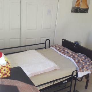 A neatly arranged bedroom with a bed and a closet in the background.