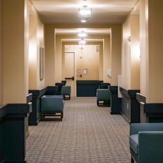 A well-lit hallway with seating arrangements on both sides.