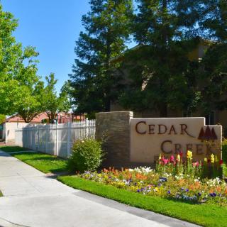 Entrance to Cedar Creek with landscaped path and sign.
