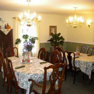 A cozy dining room with elegantly set tables and chandeliers.