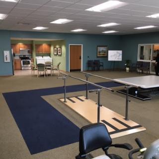 A spacious physical therapy room equipped with a rehabilitation walkway and exercise areas.