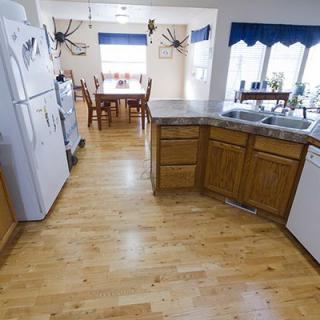 A cozy kitchen with wooden cabinets and a dining area in the background.