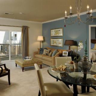 A cozy living room with a blend of elegant furniture, showcasing a chandelier, comfortable sofa, and a dining area.