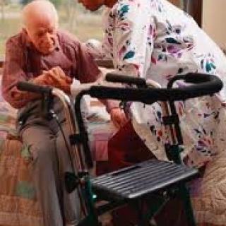 A caregiver assisting an elderly person with a walker.