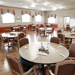 An empty dining room with neatly arranged tables and chairs.