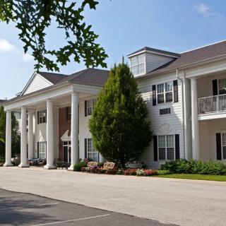 A residential building with large columns and well-maintained landscaping.